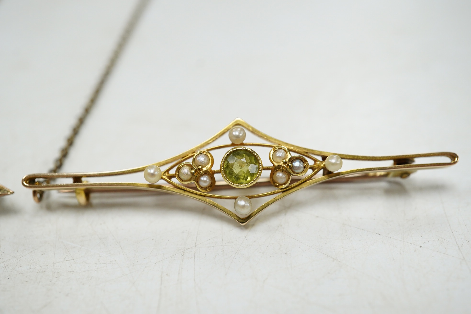 An Edwardian 15ct, peridot and seed pearl set bat brooch, 50mm, together with a similar 9ct and gem set bug brooch. Condition - fair to good